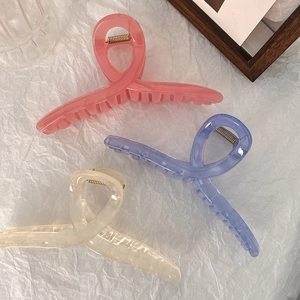 Macro detail of large 13cm jelly hair claws in pink, lilac, and cream white colors