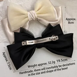 Elegant triple-layered mesh bow hair clip in cream and black with metal spring closure