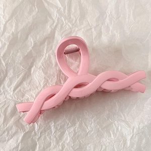 Detail view of pink twisted claw clip showing strong internal spring and secure hair grip