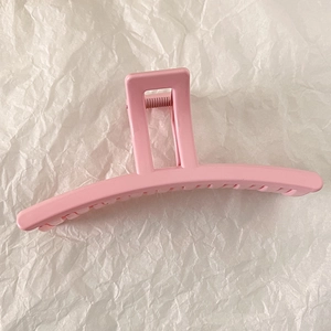 Detail of a glossy pink shark hair claw clip with a strong metal spring and smooth teeth