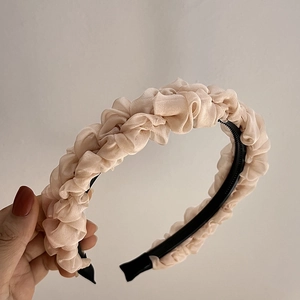 Detail of champagne pleated mesh headband showing the non-slip inner teeth and soft chiffon