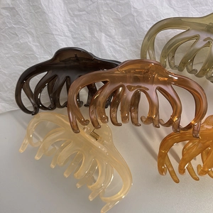 Detailed view of large translucent jelly hair claws in diverse elegant color options