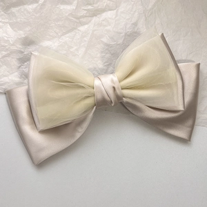 Detailed macro view of the champagne bow hair clip with layered satin and organza textures