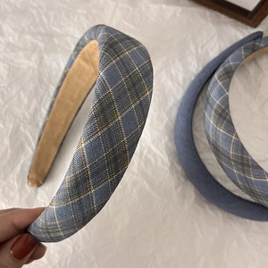 Gros plan du serre-tête large en éponge à carreaux bleus avec doublure antidérapante