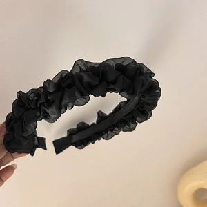 Detail view of black pleated mesh fabric headband with non-slip inner teeth design