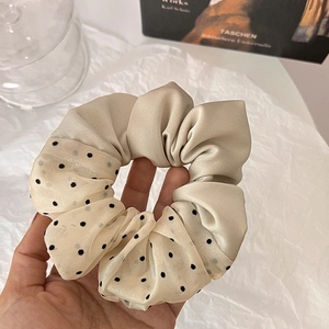 Detail of elegant champagne satin and black polka dot mesh oversized hair scrunchie