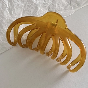 Close-up of a large amber jelly octopus hair claw clip with glossy resin finish