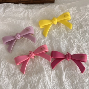 Vue détaillée de quatre barrettes à nœuds colorées avec lettrage doré Barrette La France
