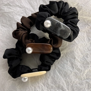 Detailed texture of ruffled chiffon scrunchies with marble resin block and pearl accents