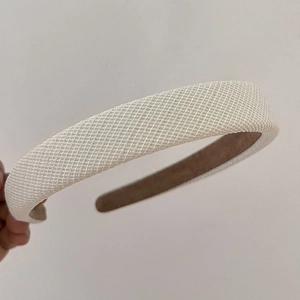 Detail view of the beige plaid fabric headband with non-slip brown suede lining