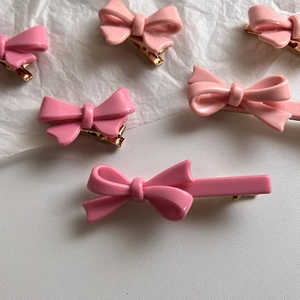 Détail de barrettes à cheveux nuds roses en résine avec pinces bec de cygne en métal