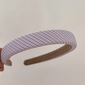 Detailed macro view of pink and light blue tweed fabric headband with non-slip brown lining