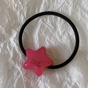Détail de l'élastique à cheveux étoile rose avec texte doré France Handmade sur lien noir