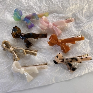 Set di sette fermagli per capelli in acetato a forma di fiocco con varie texture e colori