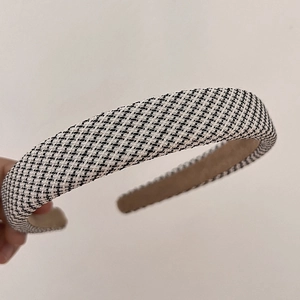 Detail of black and white tweed fabric texture on a padded vintage sponge headband