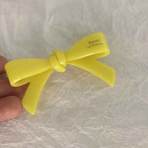 Gros plan détaillé d'une barrette nœud jaune vif avec l'inscription Barrette La France