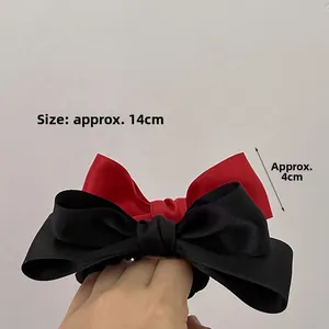 Detail view of red and black satin bow hair ties with dimensions 14cm by 4cm
