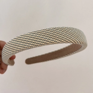 Close-up of thick light blue woven fabric headband with vintage plaid pattern texture