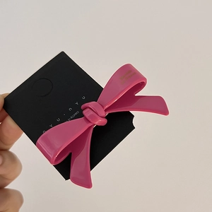 Détail d'une pince à cheveux nœud rose vif brillant sur une carte de présentation style coréen