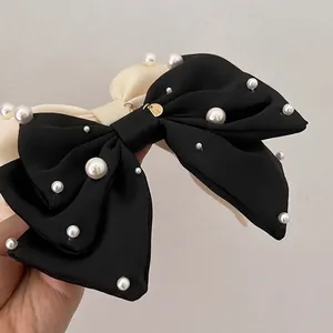 Pince à cheveux élégante en satin noir et crème avec perles blanches et étiquette dorée