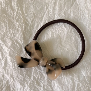 Close-up of leopard print acetate bow hair tie with durable high elasticity brown rubber band