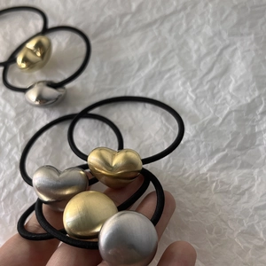 Detailed shot of high-elastic black hair ties with heart and round metal ornaments
