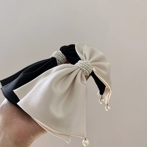 Elegant bow hair clips set in black and cream satin with luxury pearl embellishments