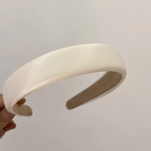 Detailed view of cream thick padded headband with matte leather finish for high volume hair