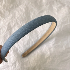 Close-up of denim blue headband showing its woven texture and non-slip inner lining detail
