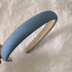 Detail view of the denim blue headband with thick texture and smooth brown lining
