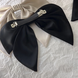 Elegant satin bow hair clip in black and off-white with metal spring fastener