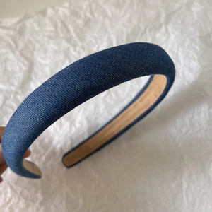 Close-up of blue denim headband texture with soft inner lining and durable U-shaped structure