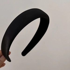 Close-up of a wide padded black headband showing soft matte fabric and sponge texture