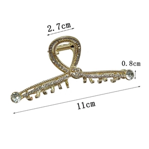 Dettaglio del grande fermaglio per capelli dorato con strass bianchi e misura di 11cm