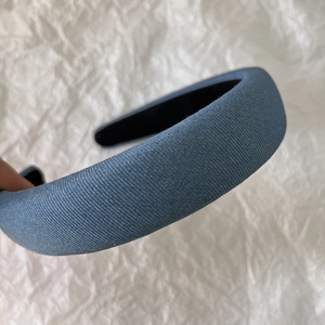 Close-up of light blue denim fabric texture on a thick sponge padded headband for women