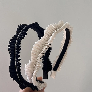 Detail of pleated fabric headbands with rhinestone accents in black and white set