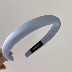 Detail of light blue padded sponge headband with handmade label and satin texture