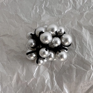 Detail of elegant pearl cluster hair tie with various sizes of white round pearls