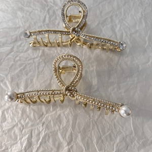 Dettaglio di fermagli per capelli dorati con strass scintillanti e perle eleganti