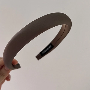 Detailed close-up showing the thick sponge padding and handmade label of this brown headband