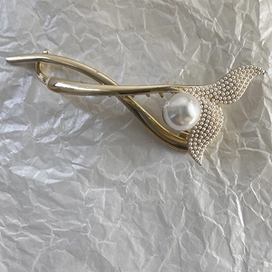 Détail de la pince à cheveux en alliage doré avec perles élégantes et strass brillants