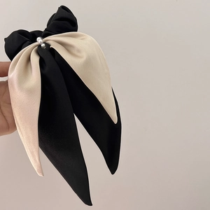Detail of elegant black and white satin ribbon scrunchie with two white pearls