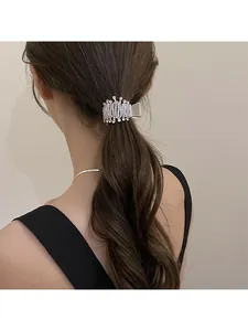 Detail of silver hair claw clip with sparkling rhinestones on brunette wavy hair
