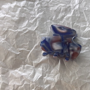 Gros plan d'une petite pince à cheveux en acétate avec un motif de marbre bleu et brun