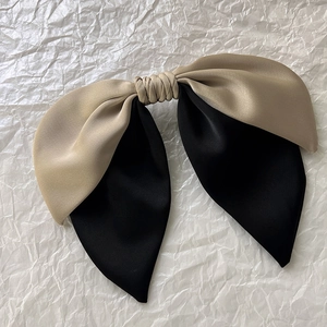 Detailed macro of a large French style champagne and black satin bow hair clip