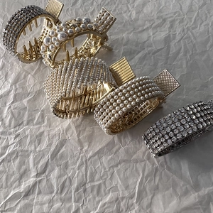 Detailed macro view of gold and silver metal hair claws with rhinestones and pearls