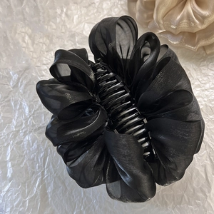 Gros plan de la pince à cheveux avec nœud en organza noir et sa texture raffinée