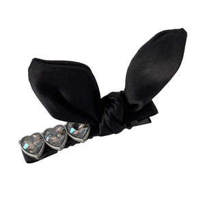 Elegant black satin bow hair clip with three heart-shaped grey crystals on a metal base