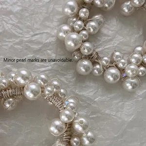 Chouchou élégant en perles blanches sur papier texturé pour des coiffures raffinées