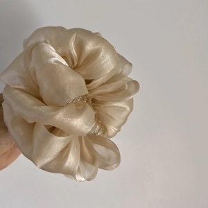 Détail d'une grande pince à cheveux en organza champagne pour cheveux épais